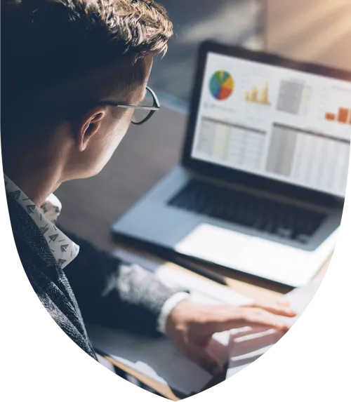 A man looking at graphs on a laptop