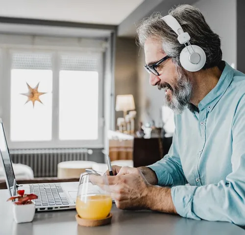 Image of a man at a laptop wearing headphones