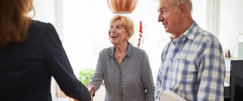 A couple shaking hands with a woman
