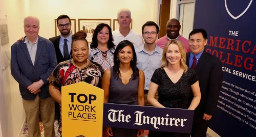 TAC staff holding top work places sign