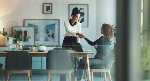Two women socializing in the office together