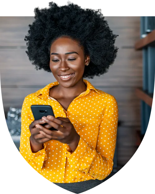 Woman in yellow shirt texting on her phone