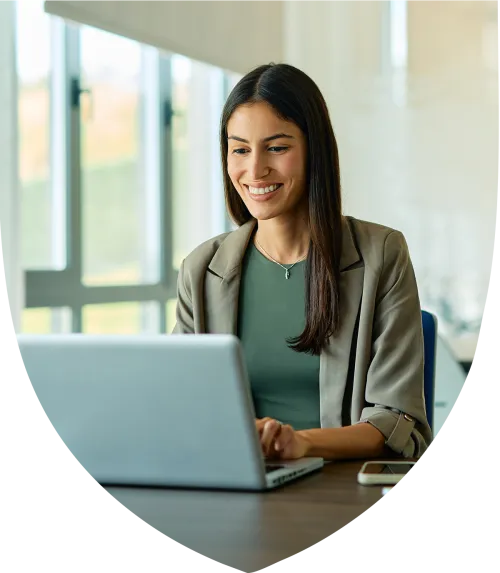 Young female professional smiling on while working on her laptop