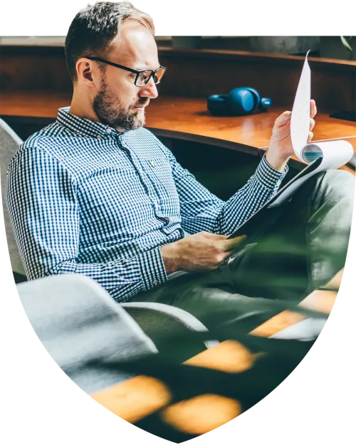 Middle aged man sitting at his desk looking through paperwork