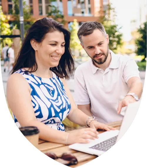 A man and woman smiling while looking at a computer together