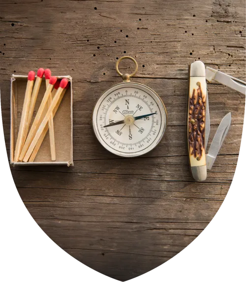 Matches, compass, and pocket knife on a table