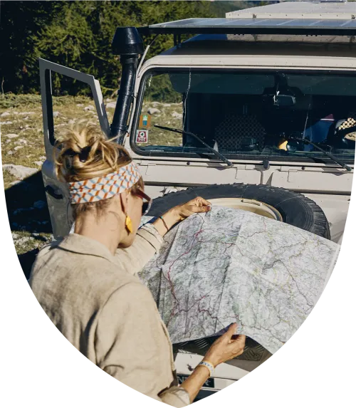 Woman looking at a map on the hood of her car