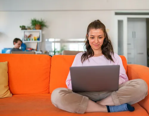 Girl sitting on her couch studying on her laptop