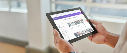 Woman holding an iPad and look at the programs and courses web page