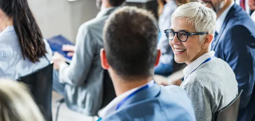 Older woman smiling and talking to young male professional