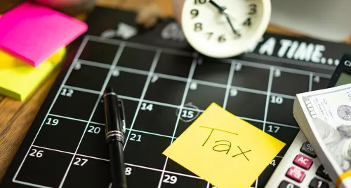 Calendar with a clock and sticky notes about taxes